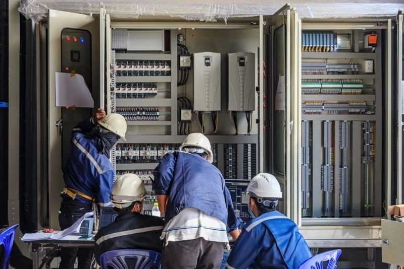 Energy Efficiency Experts inspecting an industrial electrical panel