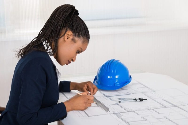 Female Energy Efficiency Engineer sitting at drafting board